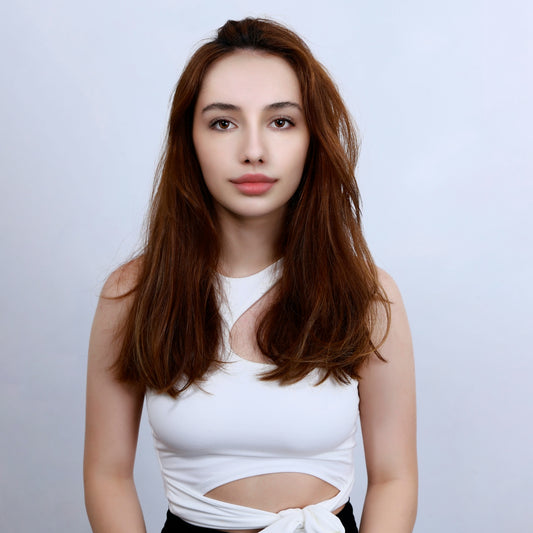 a woman with long hair wearing a white top